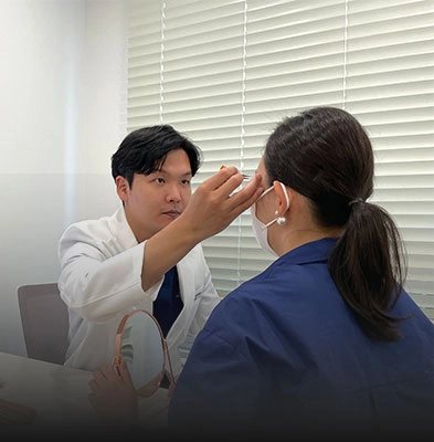 눈매를 살피며 상담 중인 의료진(흰 가운)